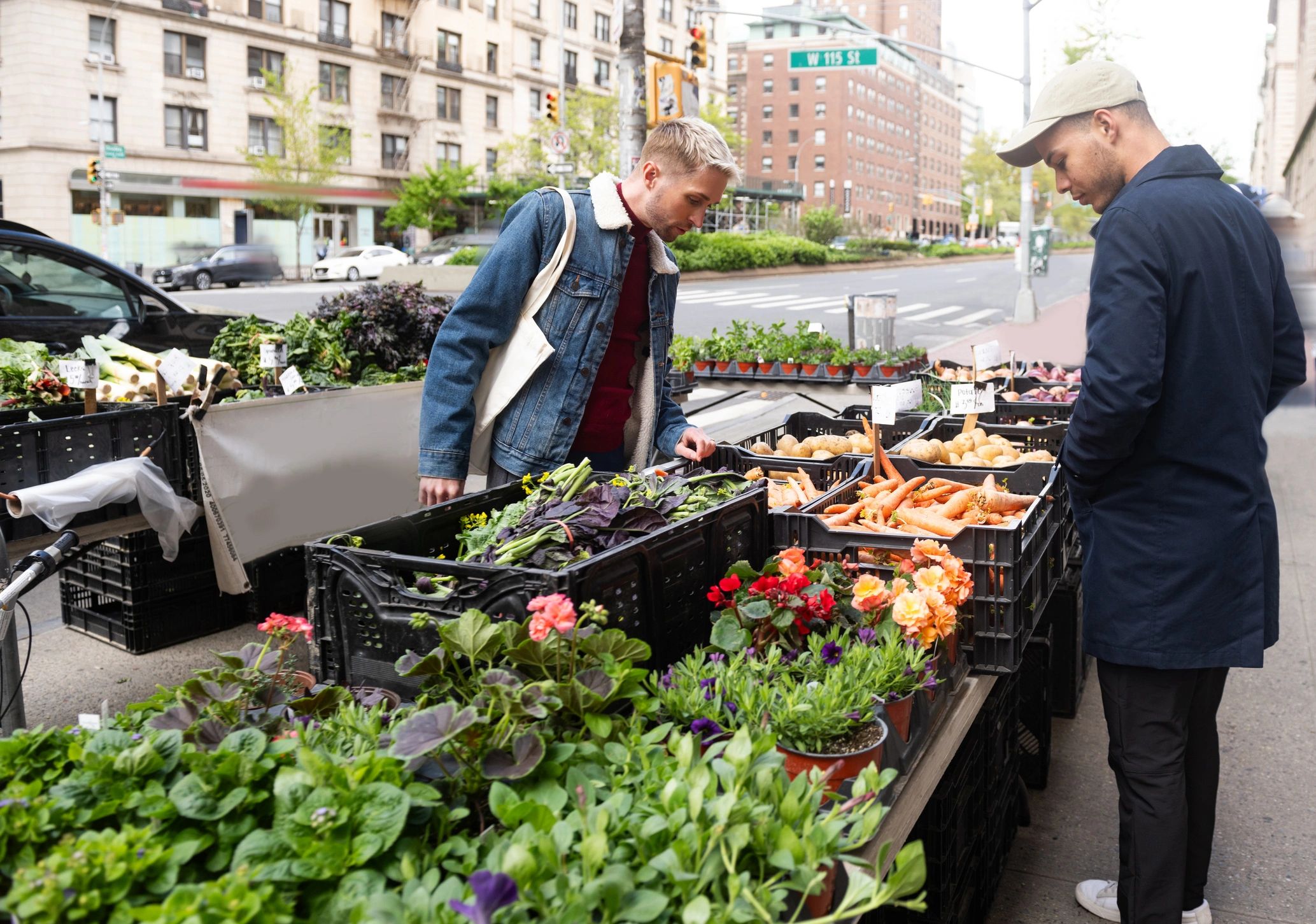 Two people selecting fresh produce at a farmers market